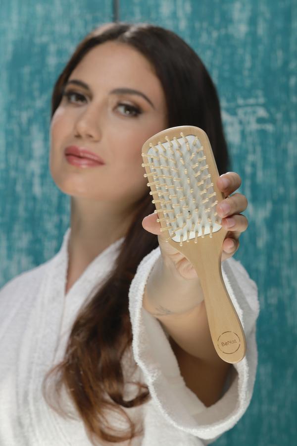 Natural wooden detangling hair brush with bamboo bristles and rubber cushioning for smooth, gentle hair care