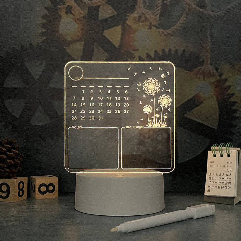 Acrylic calendar memo board with LED night light and dandelion design on desk with pen holder and glowing base