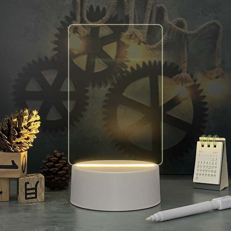 Acrylic calendar memo board with LED night light and dandelion design on desk with pen and USB base