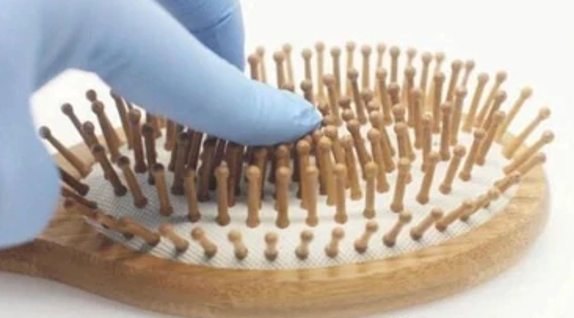 Natural wooden detangling hair brush with bamboo bristles and rubber cushioning for gentle, static-free hair care