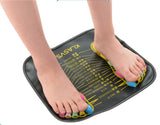 Reflexology Foot Massage Pad black with yellow acupoints map, featuring colorful toe separators on a person's feet.