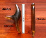 Two amber-colored acupressure massage tools, one 11.5cm curved and one cylindrical, displayed on wood for Massage Socks use.