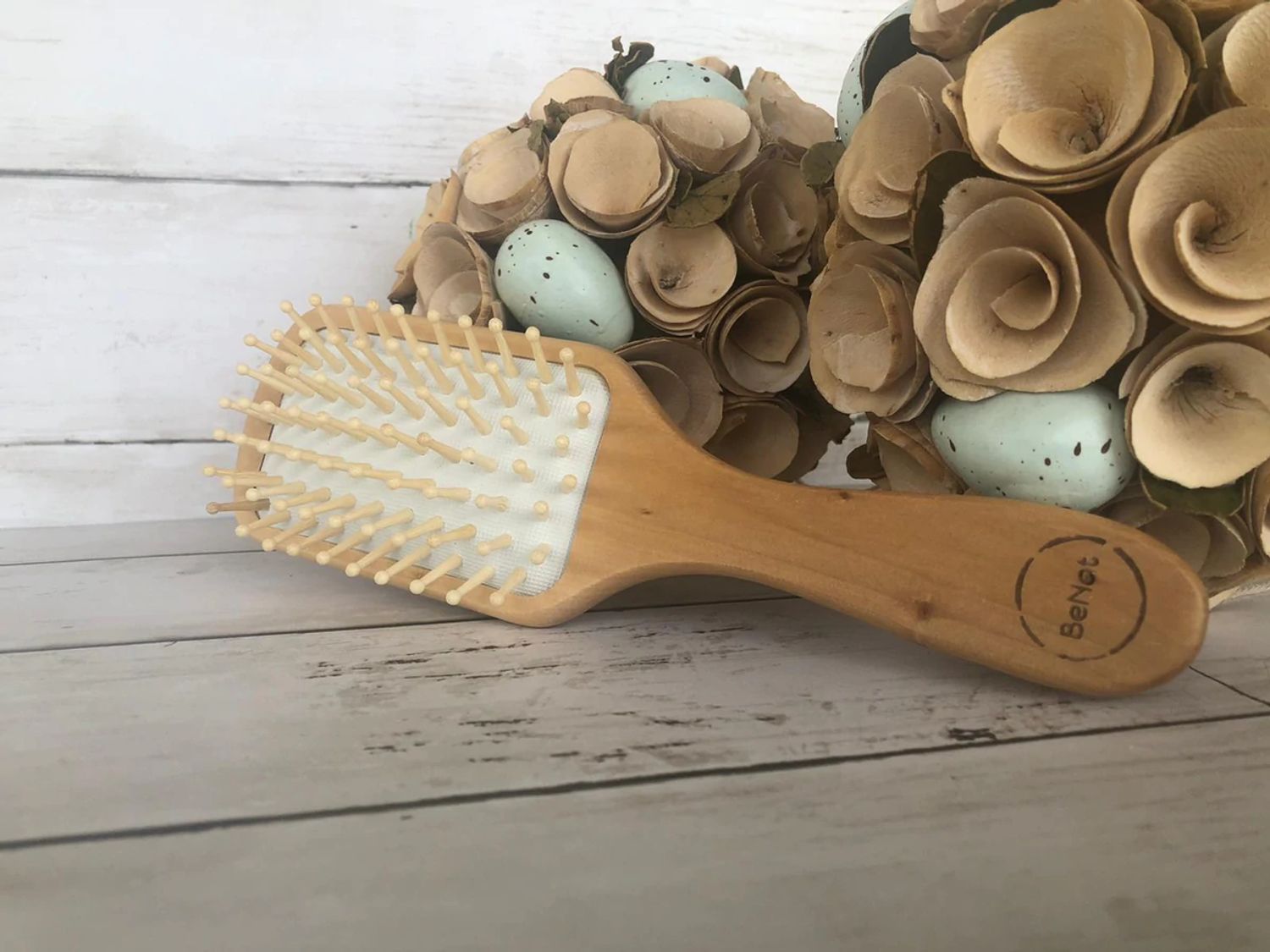 Natural wooden detangling hair brush with bamboo bristles and rubber cushioning for gentle, static-free styling